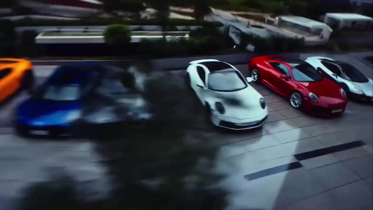 Supercars parked across a wet plaza at dusk in Hyderabad